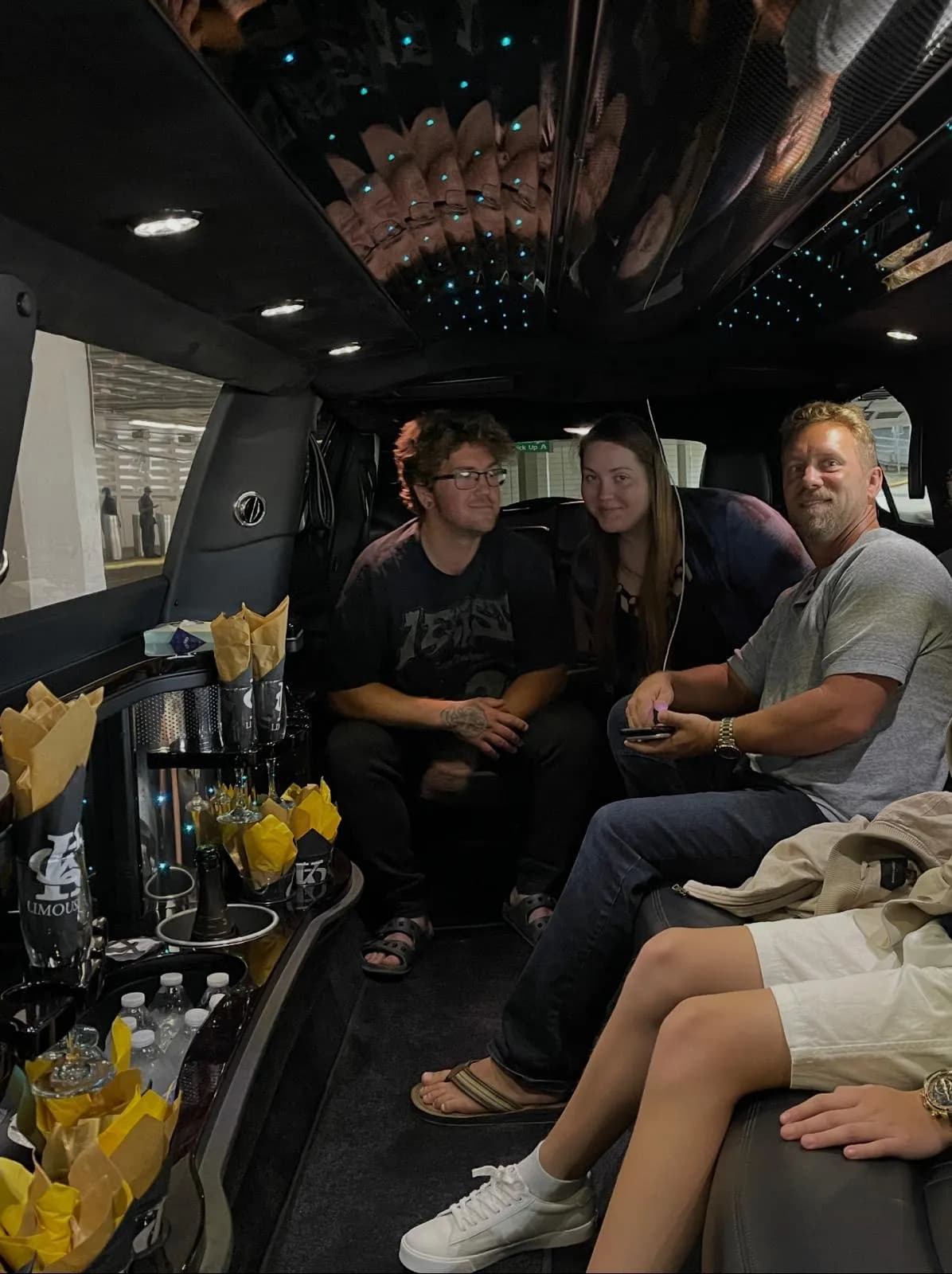 Friends relaxing inside a stretch limousine stocked with snacks and drinks