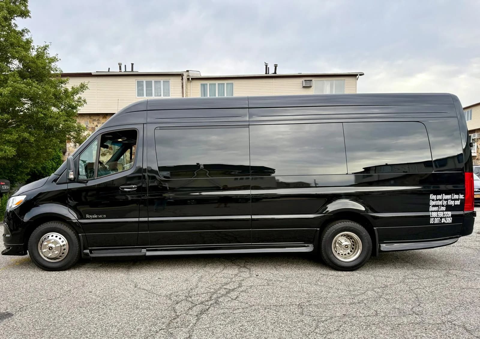 Black Mercedes Sprinter van, full side view with King & Queen branding