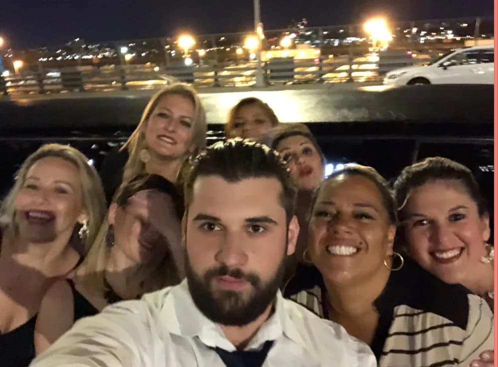 Group of friends taking a selfie inside a King & Queen stretch limousine during a night out in NYC.
