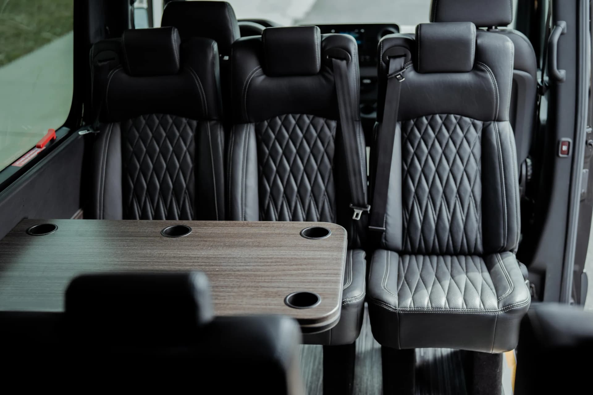 Sprinter van interior with quilted leather seats and a wood table