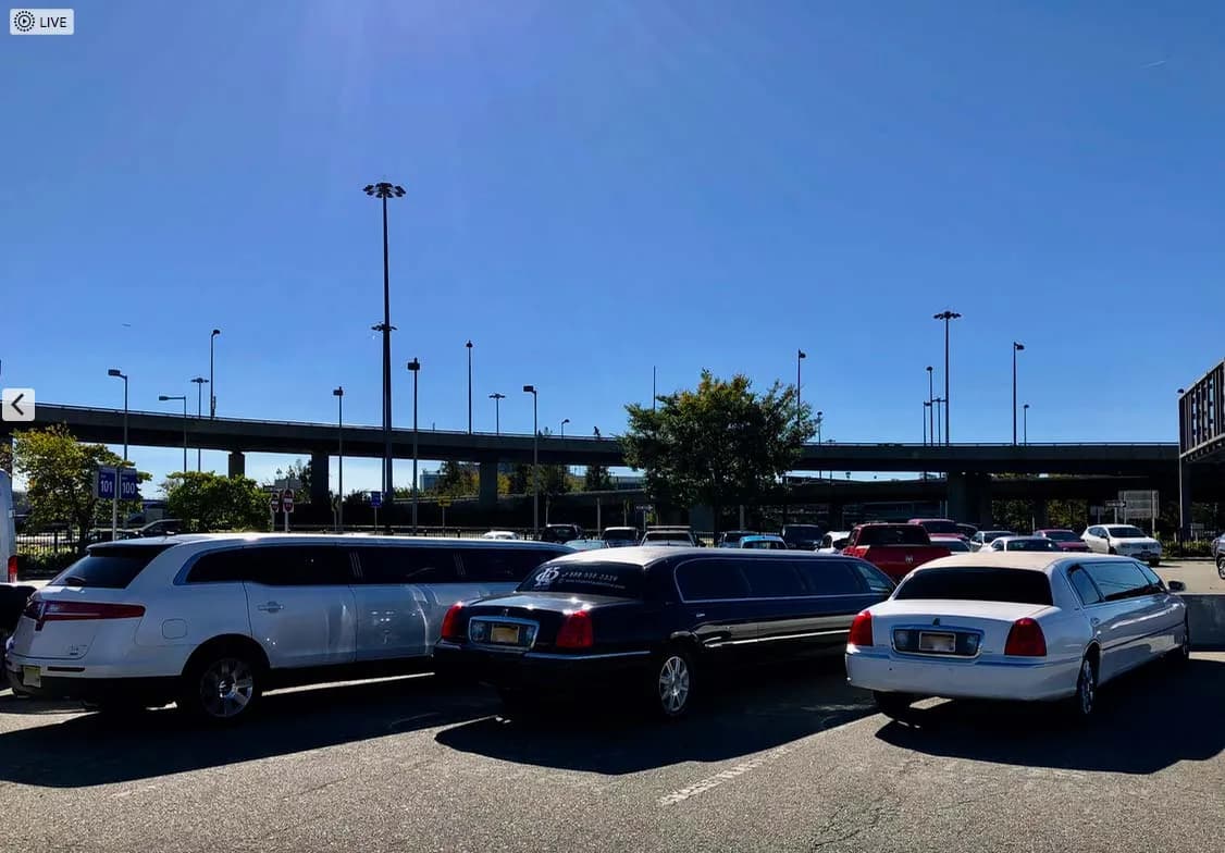Black and white stretch limousines lined up in an airport parking lot