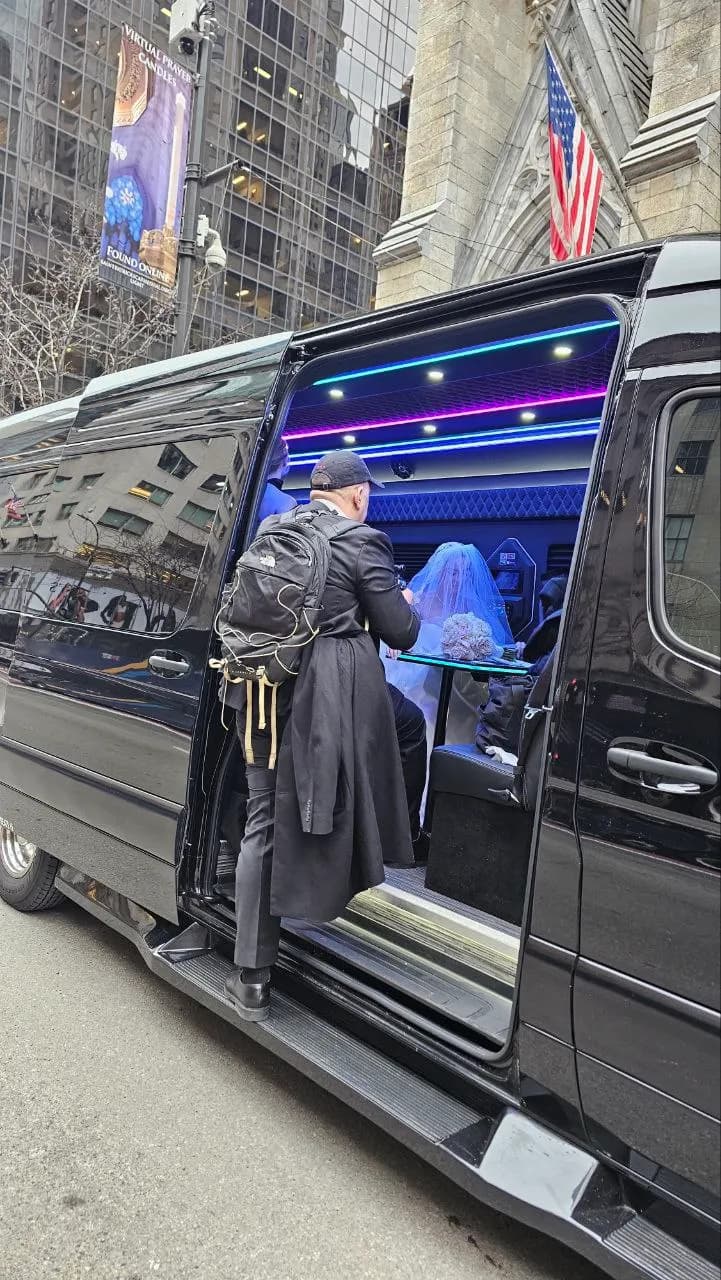 Bride seated inside a King & Queen Limo Mercedes Sprinter van outside St. Patrick's Cathedral in NYC.