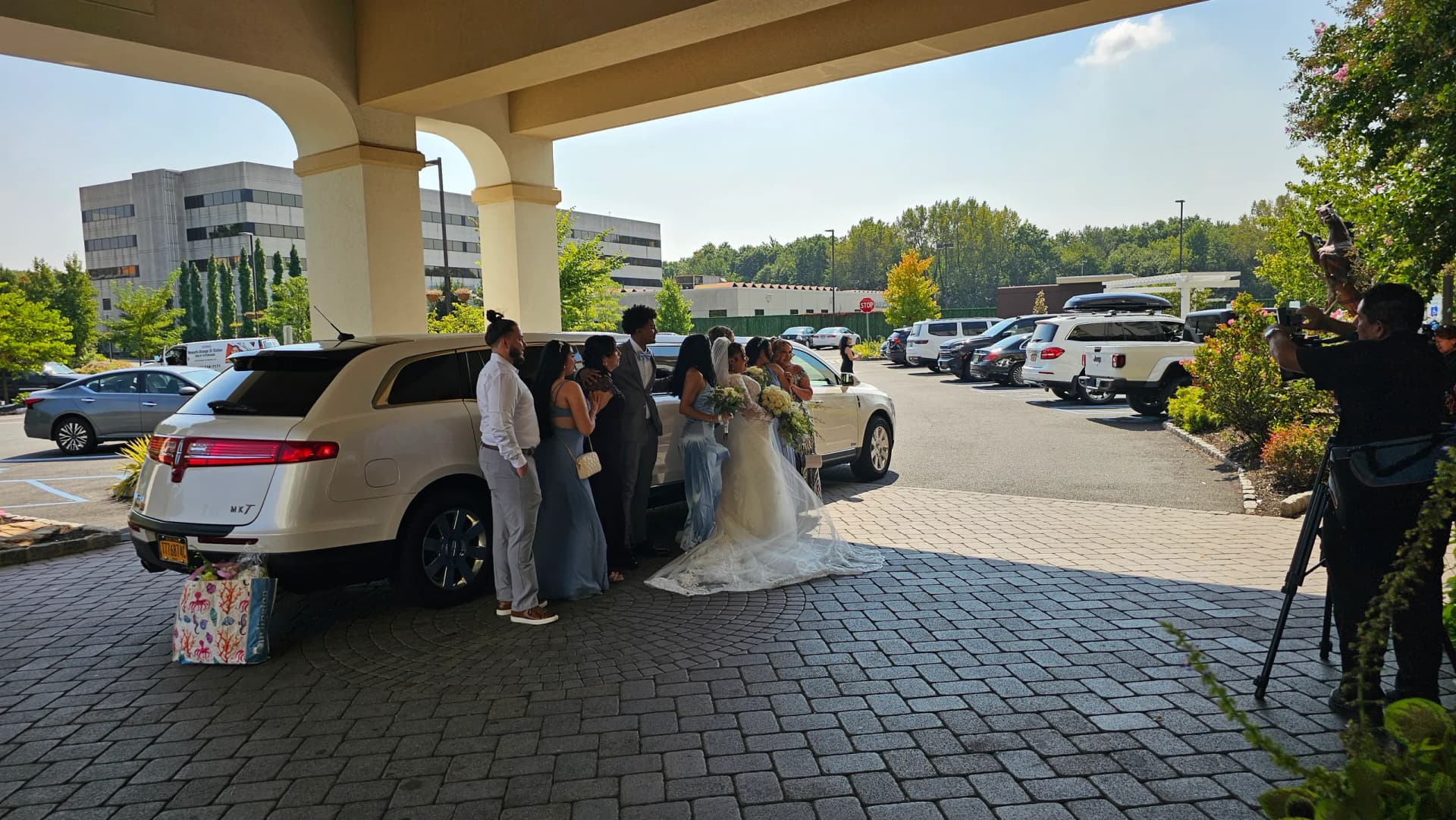 Bride and her party arriving by white Lincoln stretch limousine at the hotel