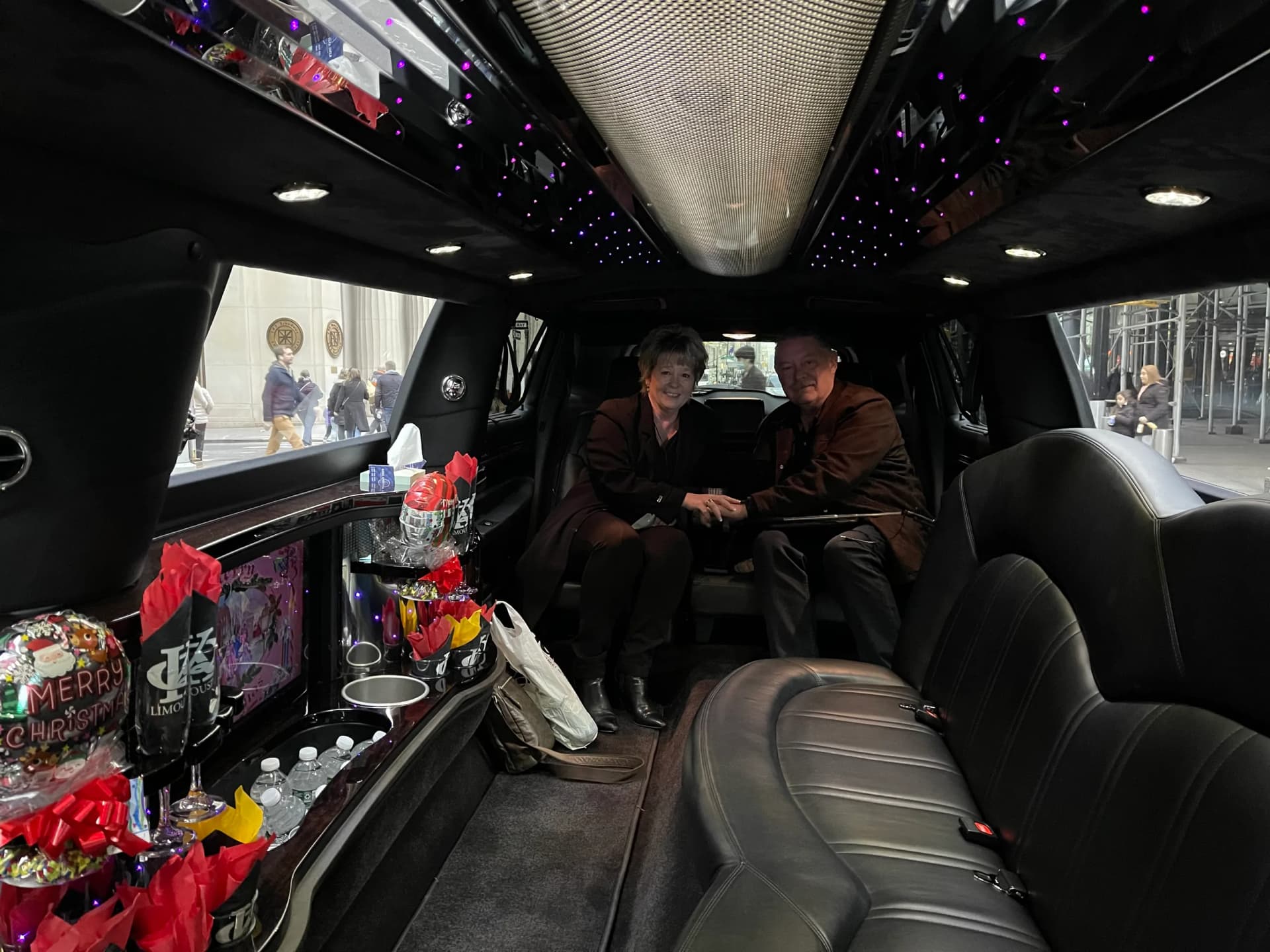 Couple inside the limousine with Christmas treats and holiday decorations