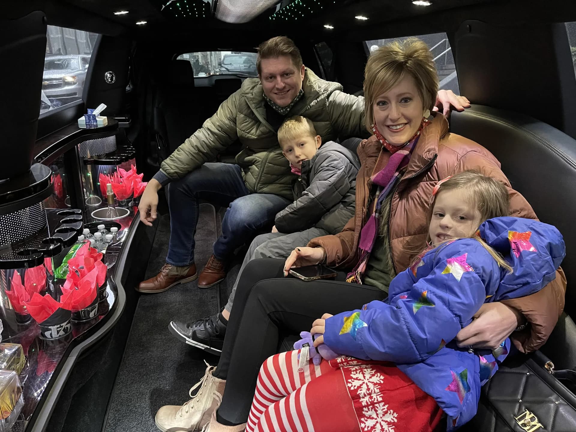 Family with kids inside a stretch limousine heading to the stadium