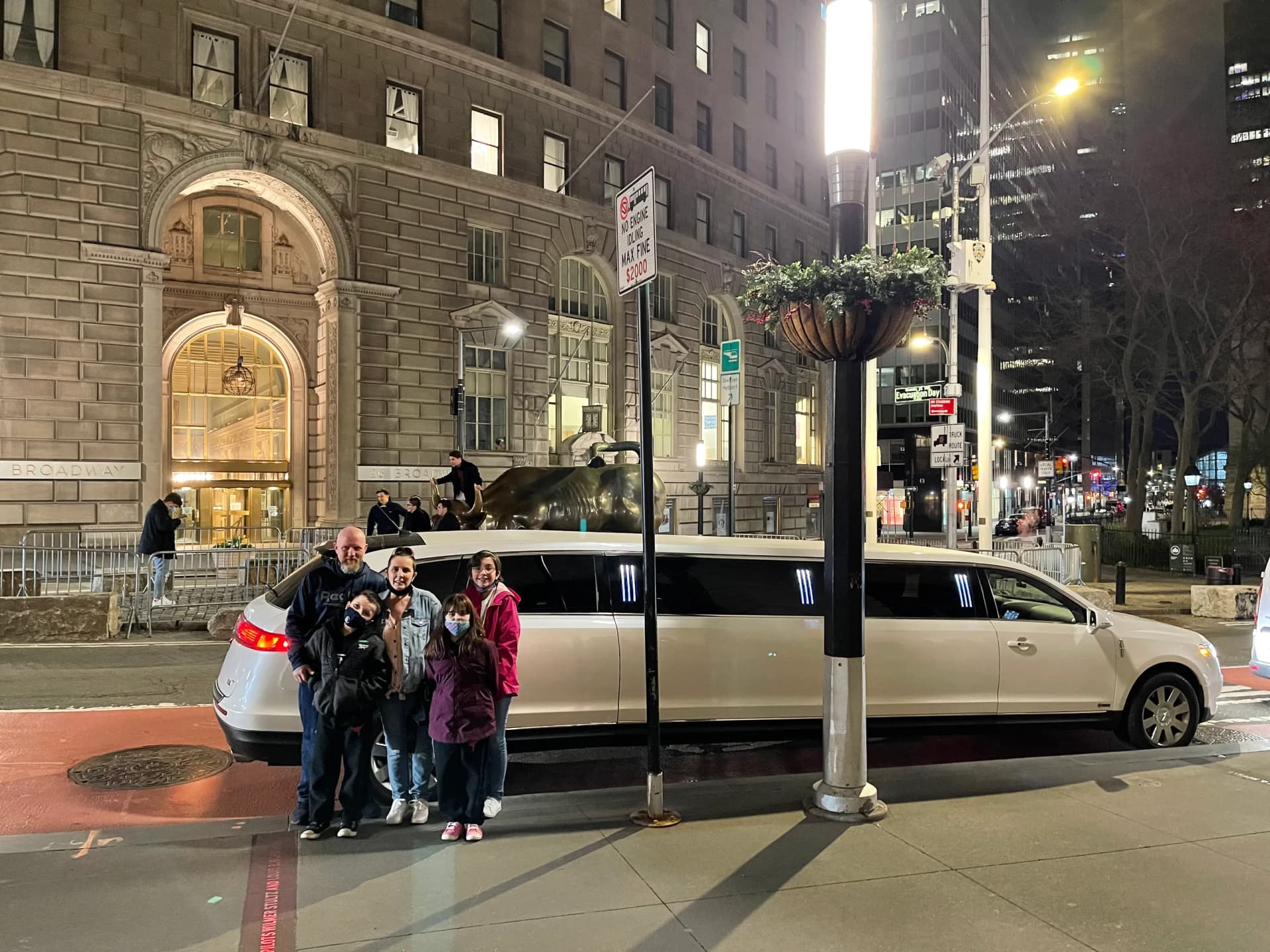 Family posing with a white stretch limo on Broadway during the holidays