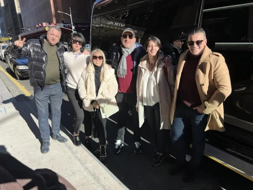 Group of six boarding their black coach outside a Midtown hotel