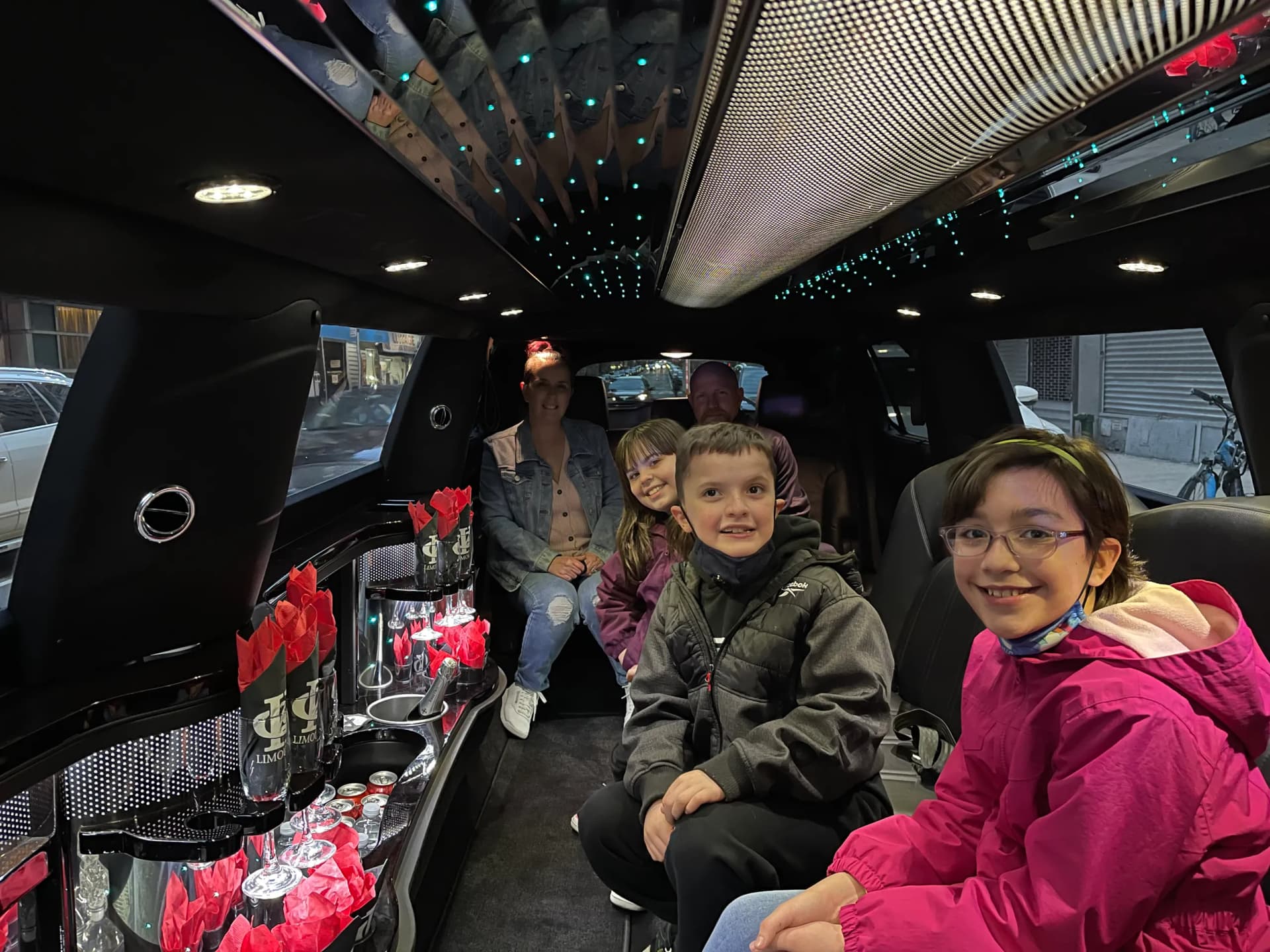 Kids smiling inside the stretch limousine on a New York City family tour