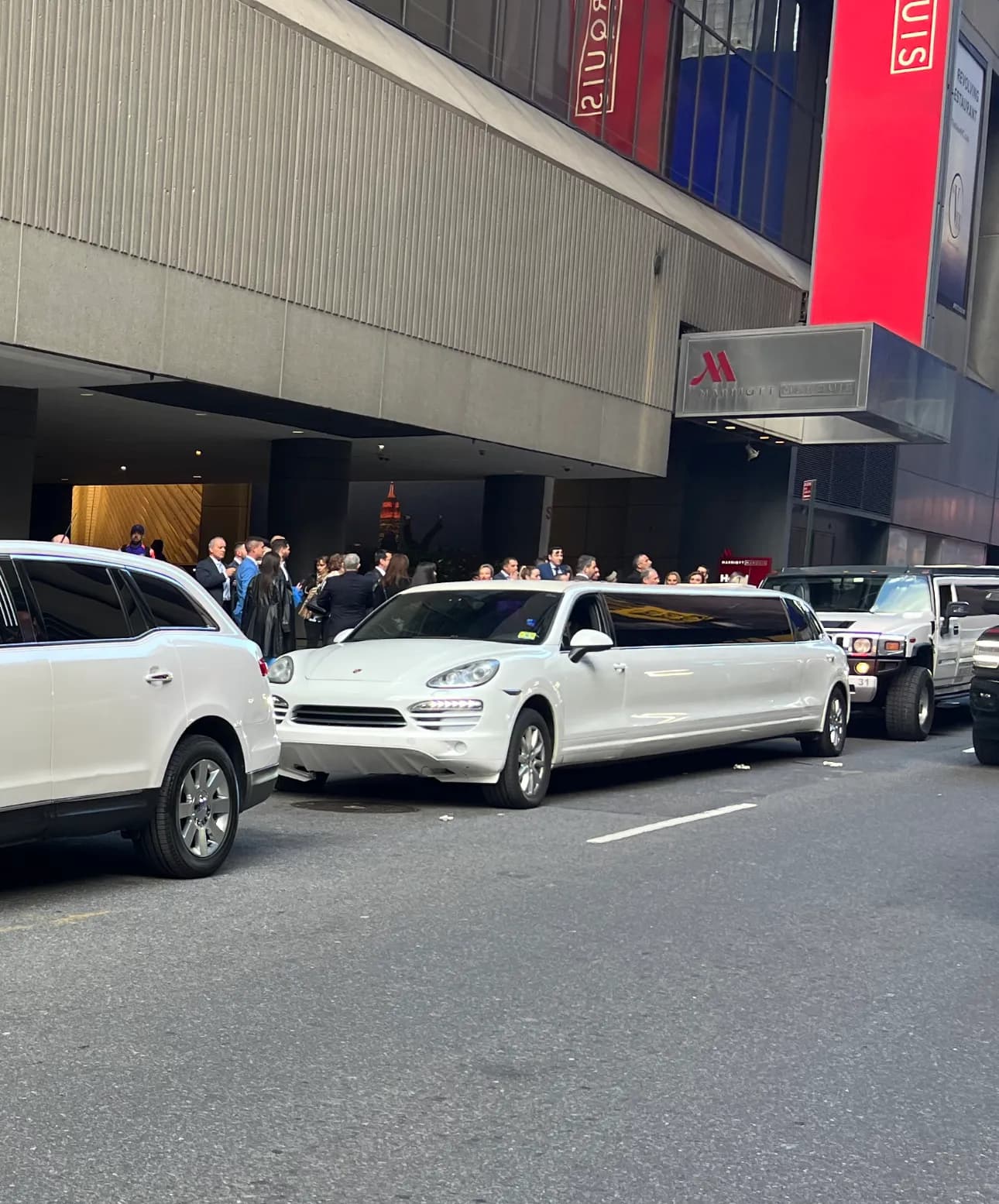 White Porsche Cayenne stretch limousine picking up guests outside the Marriott