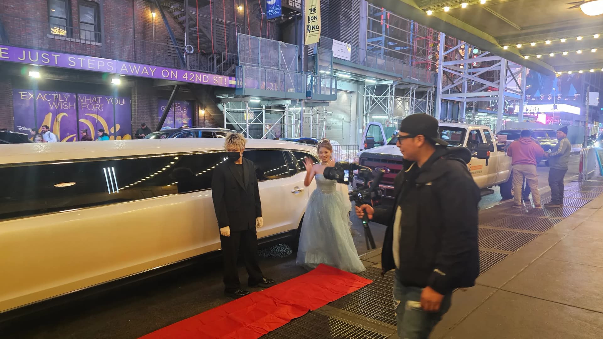 Red carpet arrival beside a white stretch limousine with the chauffeur at the door