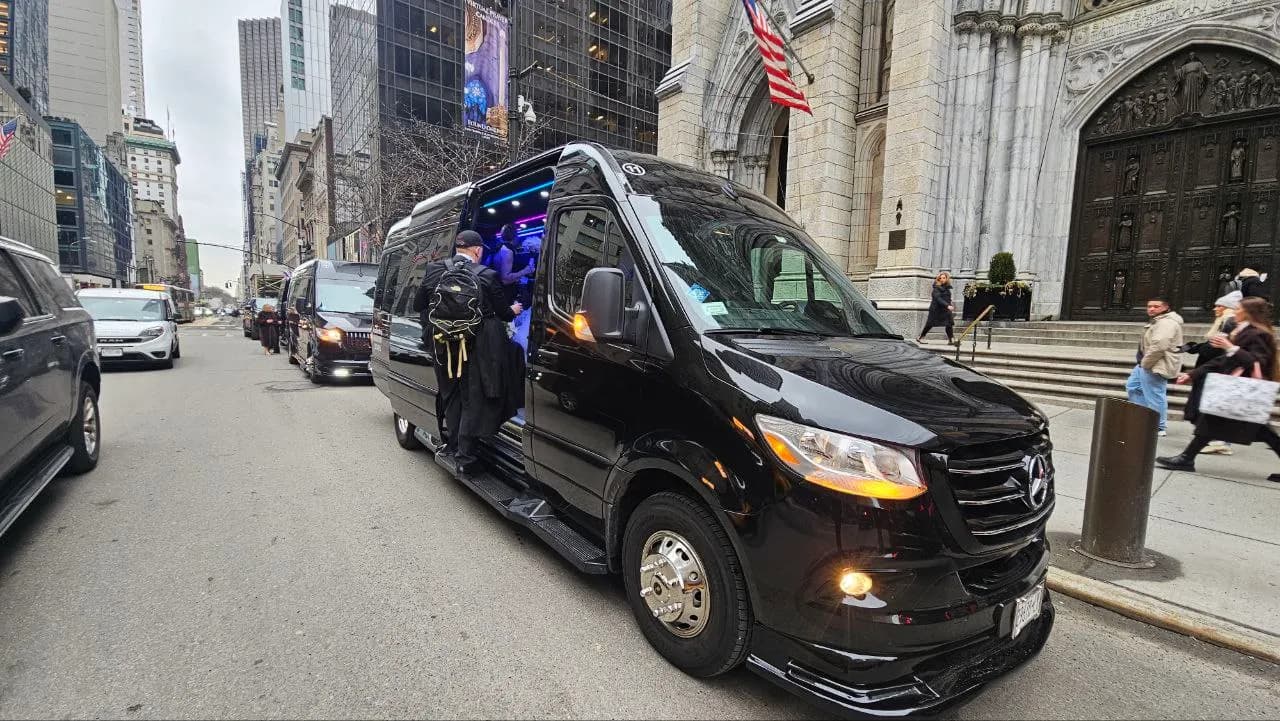 King & Queen Limo chauffeur helping guests board a Mercedes Sprinter van outside St. Patrick's Cathedral in NYC.