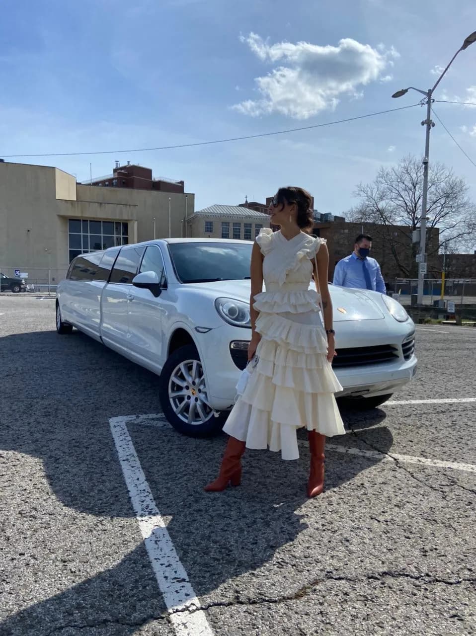 White Porsche Cayenne stretch limousine with a guest posing beside it during a special event in NYC.