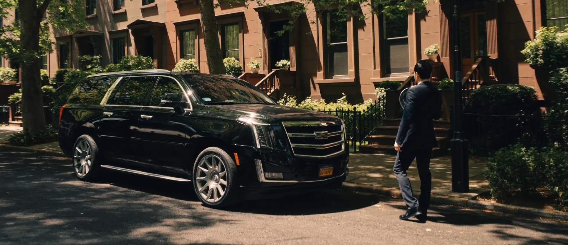 Wedding couple beside a chauffeured stretch limousine at a Brooklyn waterfront venue