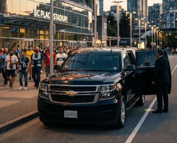 Chauffeur holding the door of a black Chevrolet Suburban outside a stadium