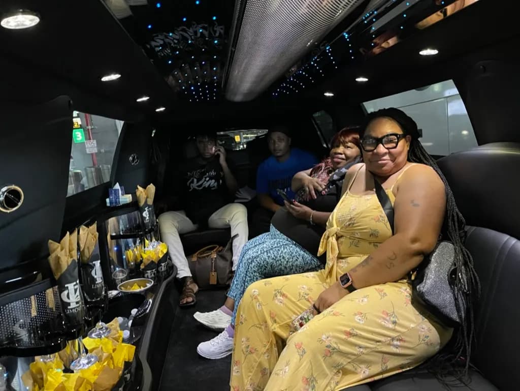 Family celebrating inside a stretch limousine with drinks and snacks at the bar