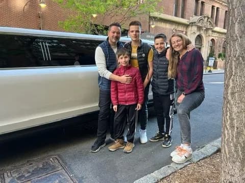 Family posing beside a white stretch limousine on a New York street