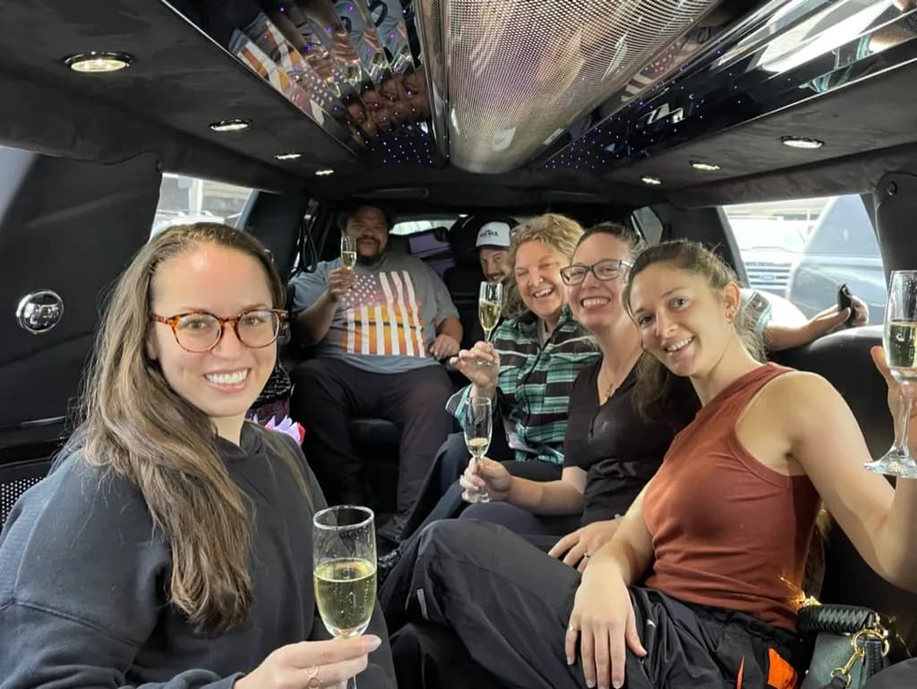 Friends enjoying champagne on a daytime stretch limousine ride