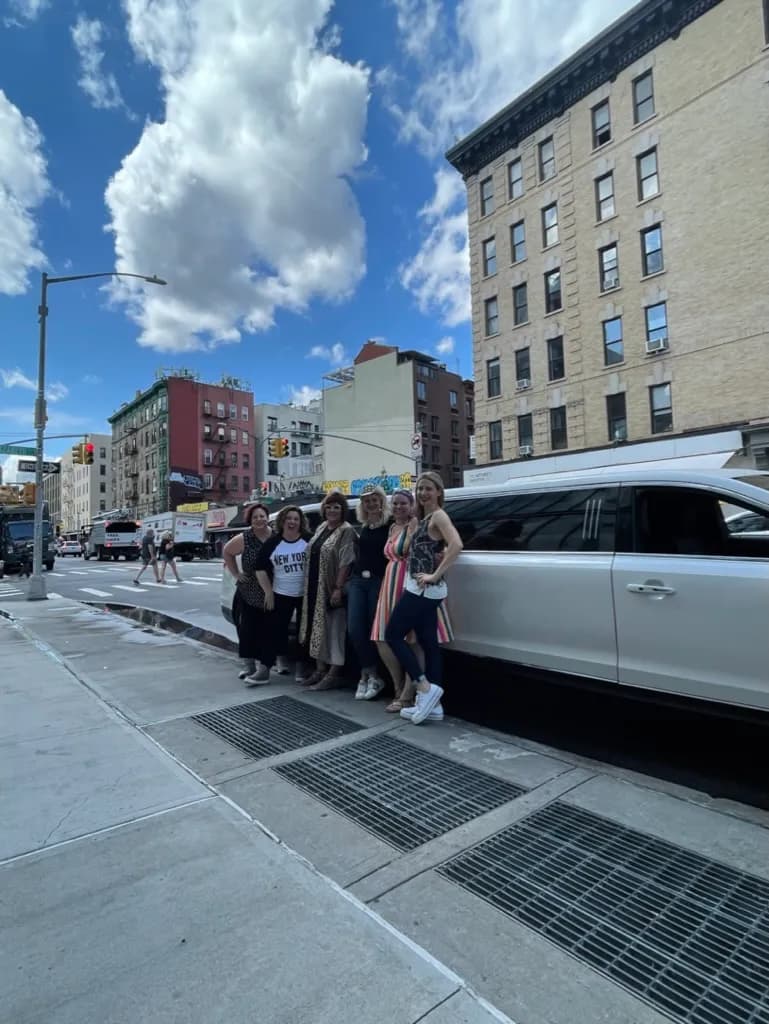 Group of friends beside a white luxury SUV on a New York street