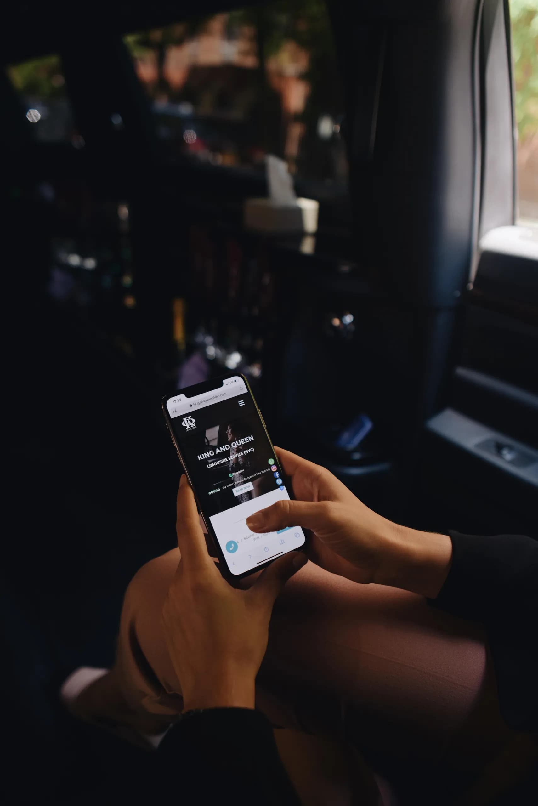 Passenger booking a ride on the King & Queen Limo website inside the limousine