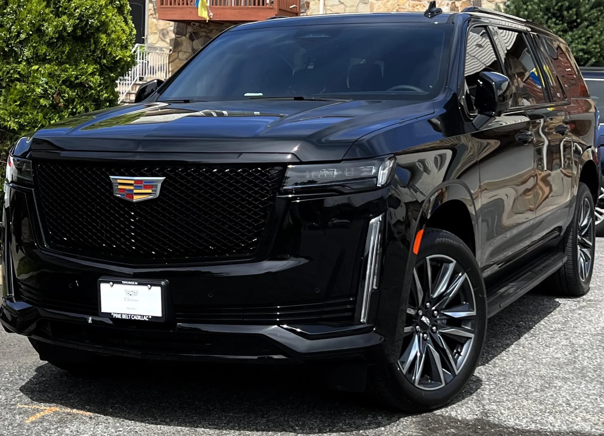 Black Cadillac Escalade Sport with dark mesh grille, front three quarter view