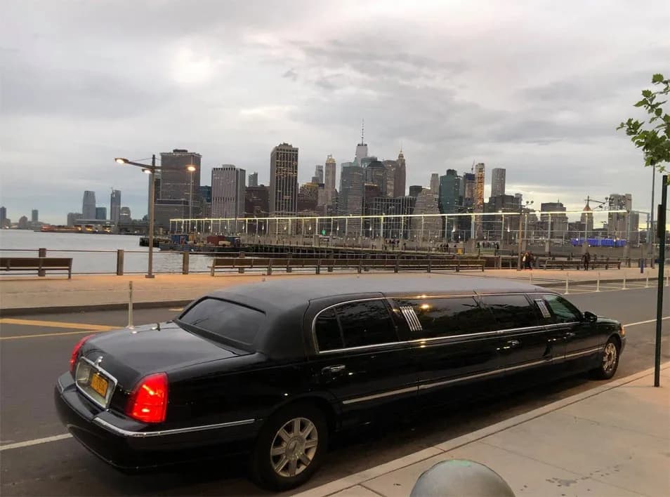 Black Lincoln stretch limousine at the Brooklyn waterfront facing the Manhattan skyline