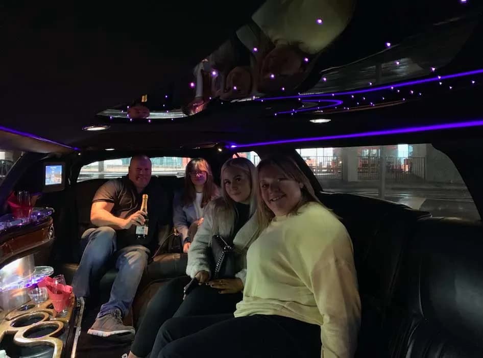 Guests on an evening tour inside a stretch limousine with a starlight ceiling