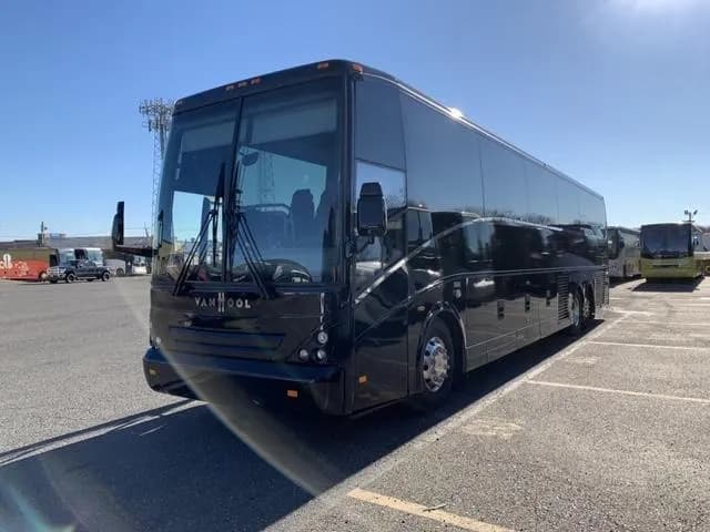 Black Van Hool coach bus parked at the depot, front three quarter view
