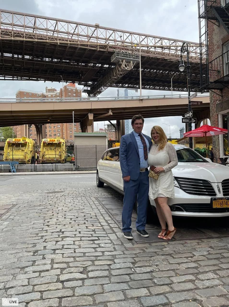 Couple with a white Lincoln limousine on cobblestones under the Manhattan Bridge in Dumbo