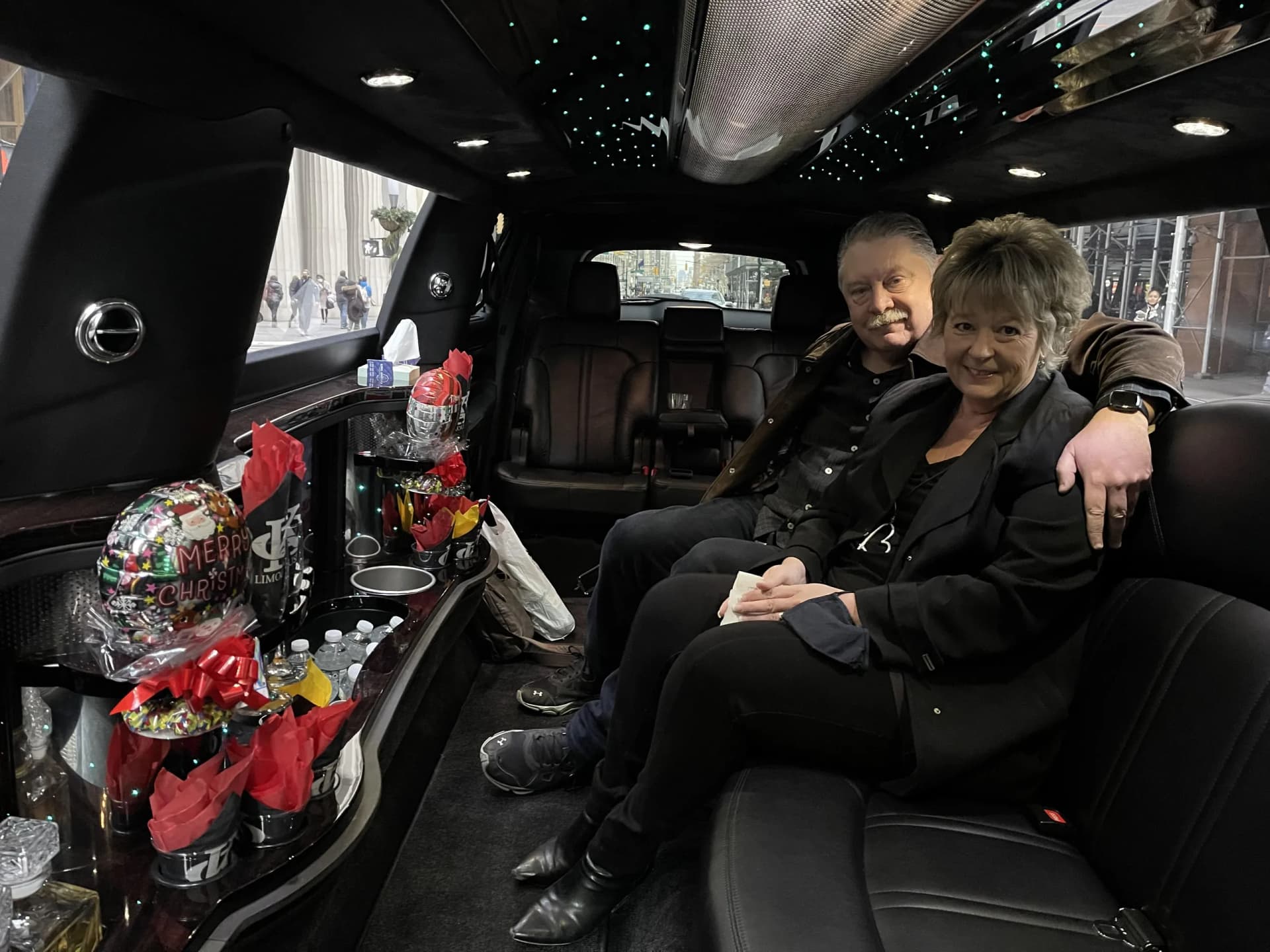 Couple on a private holiday limo tour with festive treats