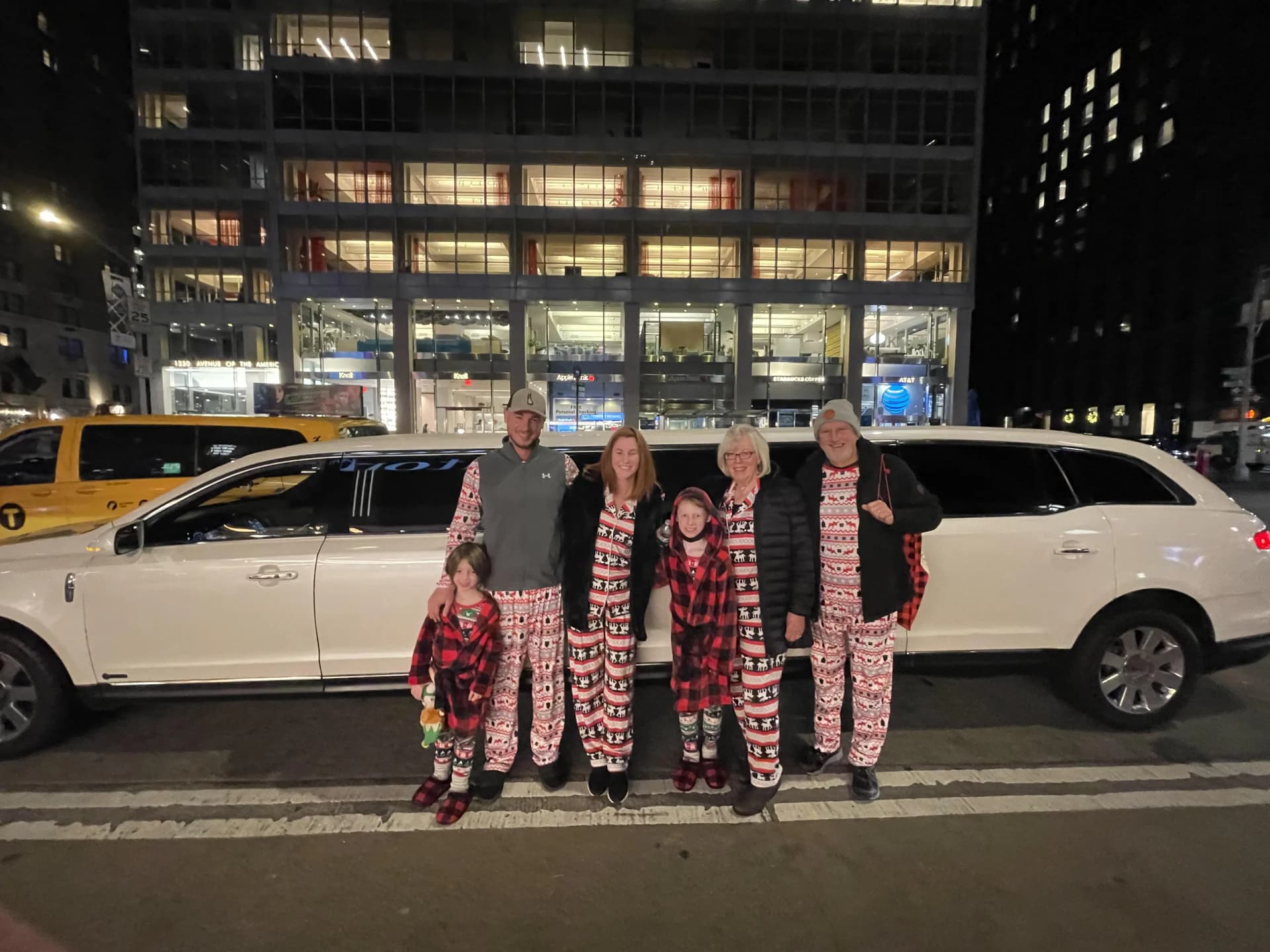 Family in holiday pajamas with their white limo before the lights tour