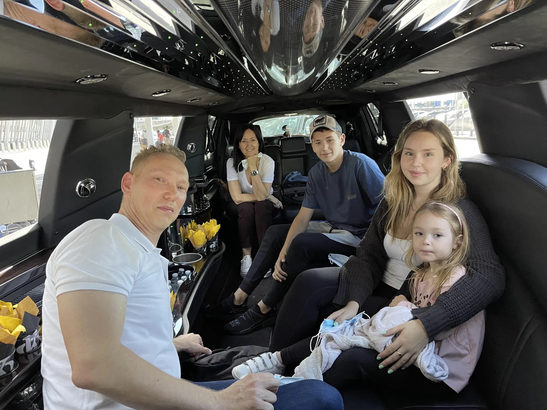 Family riding a stretch limousine with yellow tulips on the bar