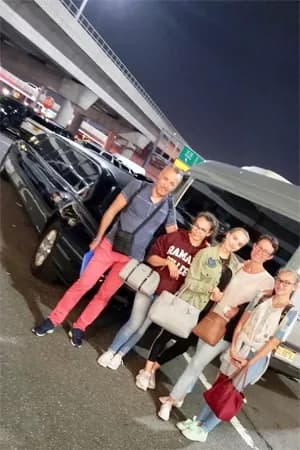 Family with their black SUV during a nighttime airport pickup