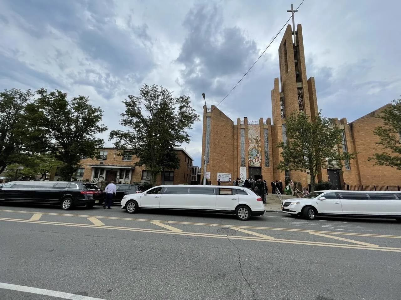 White and black stretch limousines waiting outside the church for a memorial service