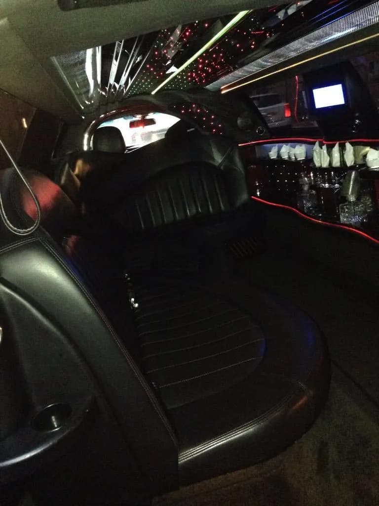 Leather back seat of the stretch limo under a red starlight ceiling