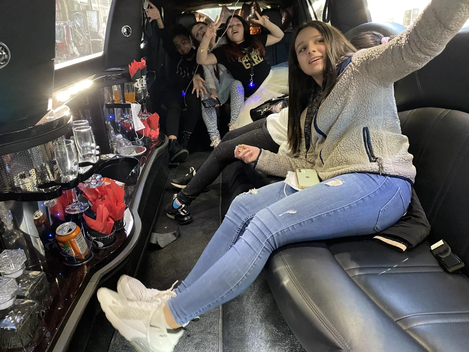 Teens dancing and taking selfies inside the party limousine
